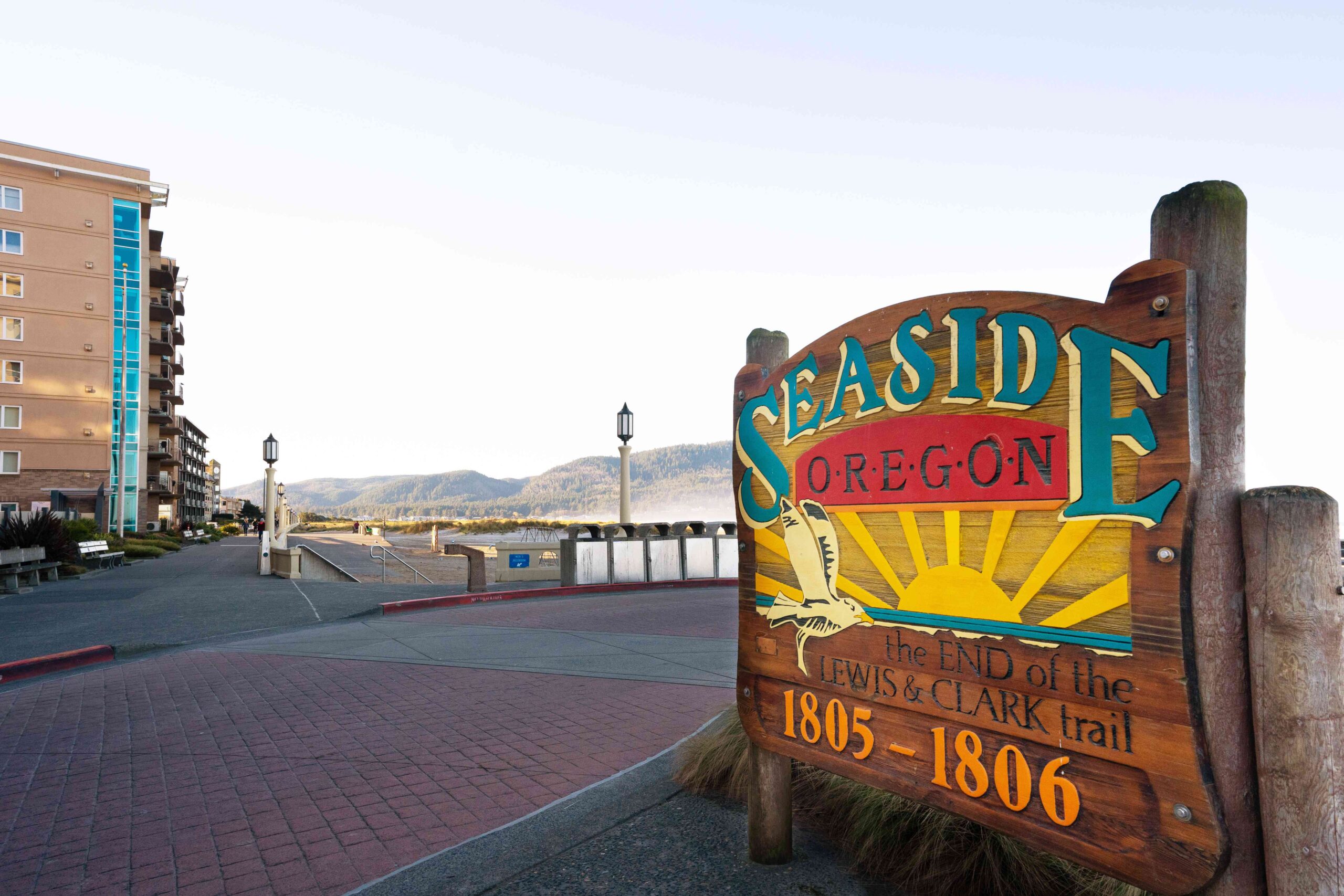 Wooden Seaside welcome sign with promenade and sea in the background